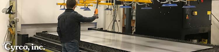 Employee preparing a metal sheet of stainless steel for fiber laser cutting into cooling tower side wall panel part